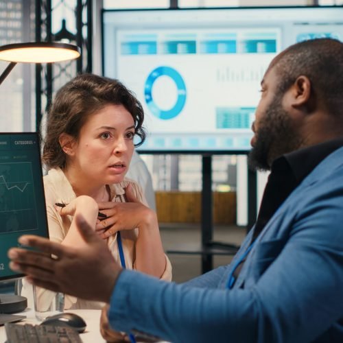 Businesswoman under pressure feeling frustrated with her coworker, being disappointed about the work tension and chaos. People failing to meet task deadline, concerned irritated boss. Camera B.